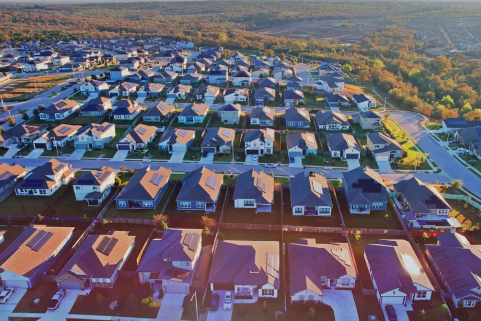 Aerial view of single-family homes with rooftop solar panels in planned development near Austin, Texas.
